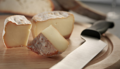 italian cheese slices wiith a knife on a breadboard