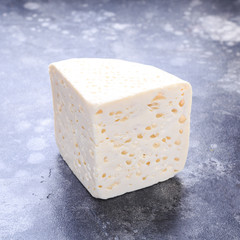 cheese with holes wood black background