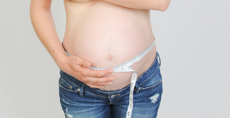 schwangere Frau misst babybauch