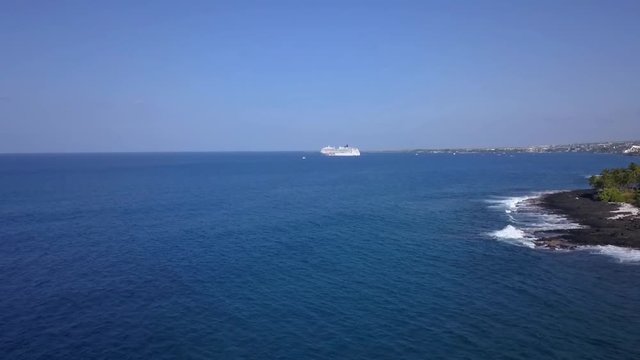 Aerial of a cruise ship parked offshore at a resort area