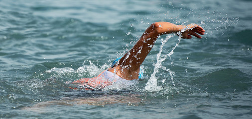 Man swimmer swimming crawl in blue sea,training for triathlon
