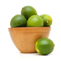 A green lemons on wooden bowl