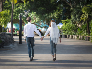 Hipster bride and groom walking on the road