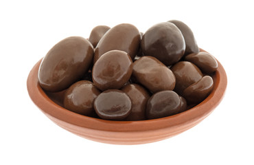 A small bowl filled with bridge mix chocolate candy isolated on a white background.