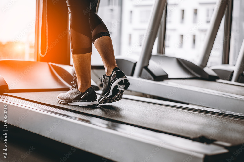 Wall mural close up on shoe,women running in a gym on a treadmill.exercising concept.fitness and healthy lifest