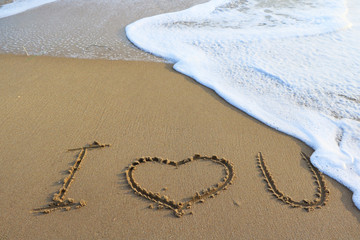 Valentine's day concept - LOVE inscription on a beach sand.valentine's written on sandy beach