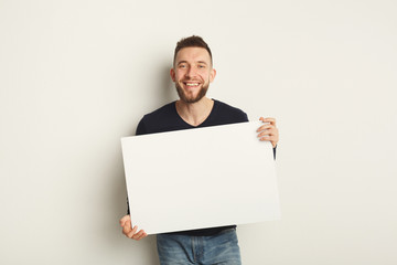 Young bearded man with blank white paper
