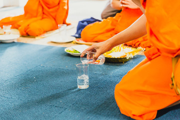 Thai monk pray and pouring water buddhist ritual in temple after beatify