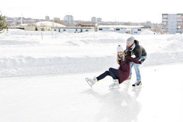 couple in sunny winter nature ice skating