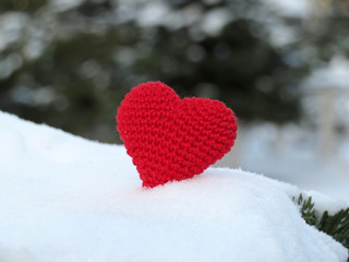 Knitted red heart on the snow. Romantic love, Valentine's day, symbol of passion