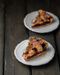 A piece of cherry pie on a white vintage plate on a wooden background. Copy Space. View blank space for text.