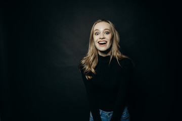 Ничего себе. Симпатичные модные довольно молодой улыбается счастливая девушка в черной толстовке, скопируйте пространства