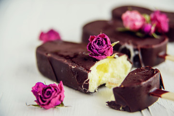 Popsicle - ice cream on a stick covered with chocolate icing, ice cream with the floral taste of the rose