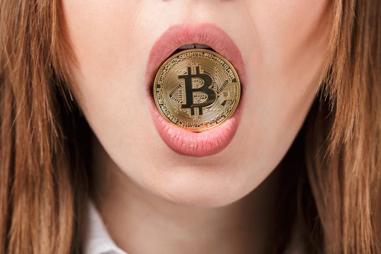 Close up of a woman holding golden bitcoin