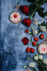 top view of strawberries, tarts and flowers on shabby background