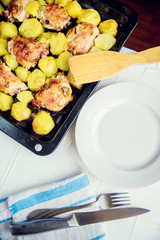 Baked chicken drumsticks on a baking sheet on a white background. Top view