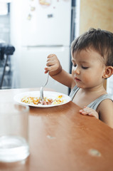 Obraz na płótnie Canvas Cute Asian child eating breakfast in a restaurant