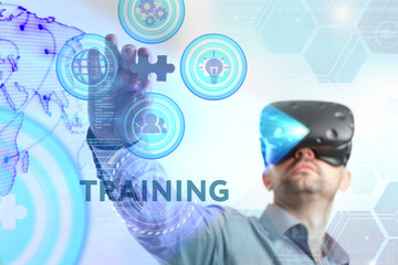 Business, Technology, Internet and network concept. Young businessman working in virtual reality glasses sees the inscription: Training