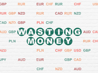 Money concept: Painted green text Wasting Money on White Brick wall background with Currency