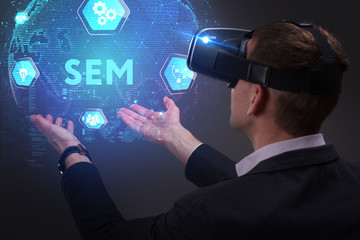 Business, Technology, Internet and network concept. Young businessman working on a virtual screen of the future and sees the inscription: SEM