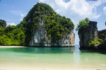 Fototapeta na wymiar Limestone cliffs by a blue lagoon on a tropical island in Thailand