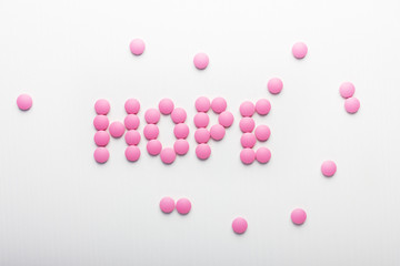 Inscription of hope pink pills on white background