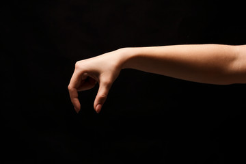 Fototapeta na wymiar Female hand picking up something, cutout on black