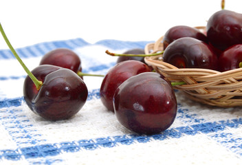 Handful of a red cherry in basket on tablecloth background