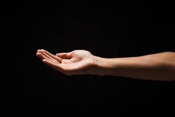 Man holding palm open isolated on black