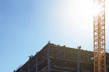 The builders of the new house are discussing a plan for further work on the top floor of the house under construction.