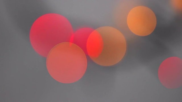 Beautiful Blurred Lights of Red And Orange Rounds. Bokeh Particles With Gray Backdrop. Abstract Motion Background
