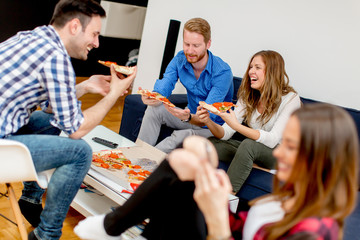 Group of young friends eating pizza