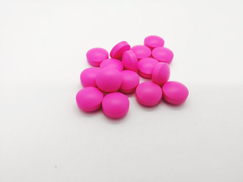 Medical and healthcare concept. Many round pink tablets of Erythromycin 250 mg. isolated on white background, used to treat or prevent many different types of infections. Selective focus.