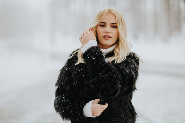 Blonde woman outside in snow winter coat