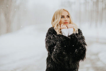 Blonde woman outside in snow winter coat