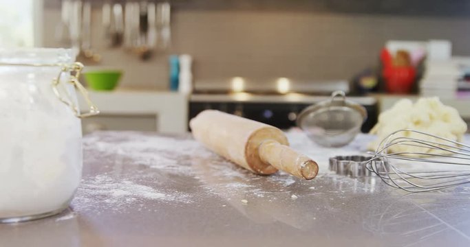 Flour jar, baking equipment and dough placed on kitchen platform  