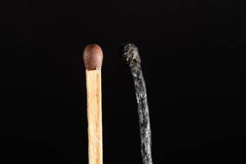 A match near completely burned on black background closeup