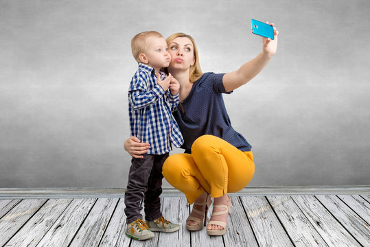 Young mother and little son are photographed on a mobile phone making selfie.Family leisure,entertainment and fun.