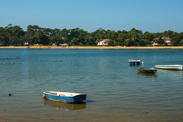 Fototapeta na wymiar French Hossegor lake with swimmers and boats during a summer day.
