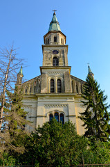Fototapeta na wymiar old church on blue sky with trees around, front view