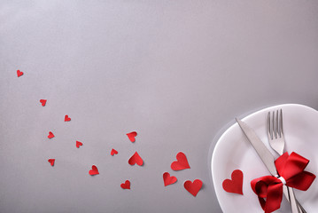 Romantic dinner decoration with many red hearts and gray background