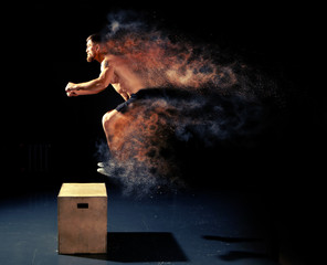 Man jumping on fit box in gym