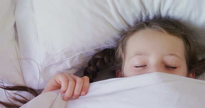 Girl sleeping peacefully with blanket covered on face 