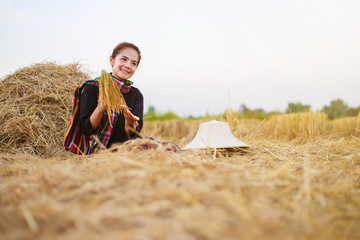 farmer woman holding a rice with the straw in field