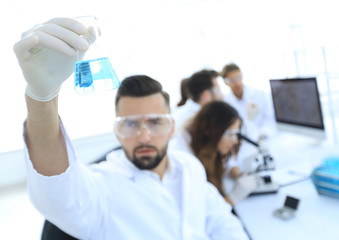 biochemist with flask Petri sitting at a Desk