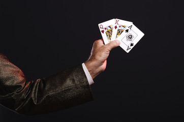 Magician shows trick with playing cards. Manipulation with props. Sleight of hand.