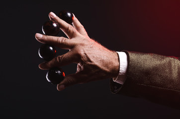 Magician shows trick with magic balls. Manipulation with props. Sleight of hand.
