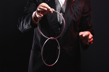 Magician shows trick with metal rings. Manipulation with props. Sleight of hand.