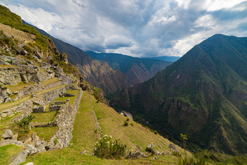 Fototapeta na wymiar Machu Picchu terraces steep view from above to Urubamba valley below. Peru travel destination, tourism famous place.