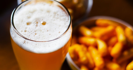 pint of lager beer in a glass, set of various snacks, a standard set of drinking and eating in a pub